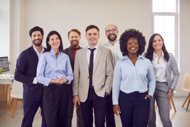 Ofisteki mutlu ve çeşitli iş adamlarının portresi. İş arkadaşlarından oluşan çok uluslu ekip, olumlu ve işbirlikçi bir çalışma ortamı yansıtan bir takım çalışmasıyla meşgul..