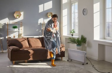 Genç adam çok soğuk kış boyunca evinin içinde donuyor. Sıcak battaniye giymiş üzgün bir adam, titreyen çoraplar ve elektrikli ısıtıcıyla oturma odasındaki halının üzerinde ileri geri yürüyen bir adam. Isıtma sorunu kavramı