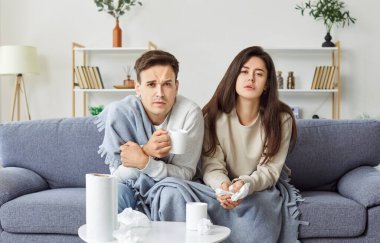 Evde virüs, soğuk algınlığı ya da grip geçiren evli bir çift var. Ateş ve hastalıktan hasta görünüyorlar, iyileşmek için sağlık hizmetine ihtiyaçları var. Hastalık, evde hasta olmanın etkisini gösteriyor..