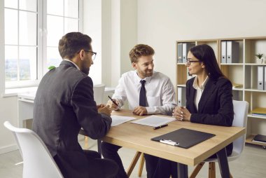 Bir grup insan ofiste toplanıyor. Komisyoncu müşterilerle görüşür. Genç bir çift kredi alıyor ve kontrat imzalıyor. Erkek ve kadın anlaşma yapar, iş ortağı olurlar ve kağıt anlaşmasına imza atarlar.