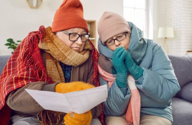 Zavallı yaşlı aile çiftimizin ev ısıtmasını karşılayacak paraları yok ve birlikte oturuyorlar. Kışlık şapkalar, eldivenler, ekoseler ve kağıt faturalı paltolar ya da oturma odasındaki kanepede oturuyorlar.