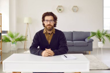 Modern ofiste masada oturan ciddi sakallı bir iş adamı. Gözlüklü, gömlekli ve kameraya bakan yakışıklı bir genç. Profesör, HR öğretmeni, mali danışman portresi.