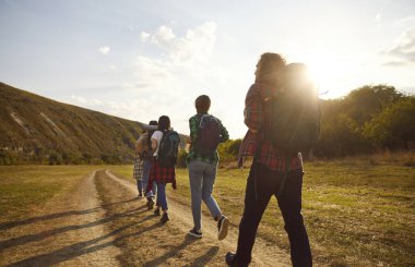 Turistler sıranın gerisinde yürüyor, doğa yürüyüşü yapıyor, gezici gruplar kırsal bölgelere, patikalara gidiyorlar. Arkadaşlar mutlu sırt çantası turlarının, eğlence aktivitelerinin, doğal ortamlarda dolaşmanın keyfini çıkarırlar.