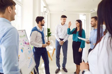 Modern ofiste iş projelerini ya da girişimleri tartışan kendine güvenen genç iş adamlarının portresi. İş arkadaşları ve şirket çalışanları bir toplantıda iş arkadaşlarıyla konuşuyor..