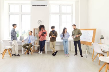 Profesyonellerden oluşan bir ekip bir ofis toplantısına katılmış, konuşuyor ve iletişim kuruyor. İnsanlar ekip çalışması ve işbirliği, iş personeli arasındaki etkili iletişimin önemini vurguladı.