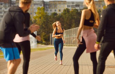 Koşmak, arkadaşlar bayan sporcuyu beklemek, mutlu insanlar spor başarısını paylaşmak, dışarıda antrenman yapmak, iyi takım çalışmasını kutlayan personel açık havada takım oluşturma aktivitesiyle meşgul olmak.