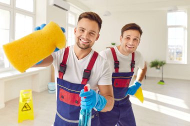 Hizmet personelinden kendini işine adamış iki mutlu adamın portresi. Eldiven giyen bu insanlar temizlik ve temizlik çalışmalarına katkıda bulundukları için mutluluk saçıyorlar..