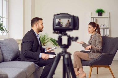Adam bir kadınla röportaj yapıyor, kamerayla kaydediyor ya da canlı yayın yapıyor. TV röportajı, haber programı, talk show ya da halkla ilişkiler. Muhabir, bir kadınla konuşuyor..