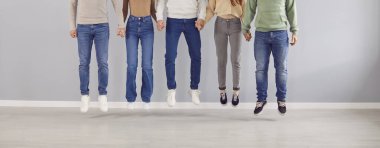 Bacaklar, atlama hareketinde kot giyen ve el ele tutuşan insanları birbirine yaklaştırır. Pantolon, kostüm pantolonu, günlük kıyafet, moda kıyafetleri, çeşitli takımlar içinde birlikte atlayan arkadaşlar. 