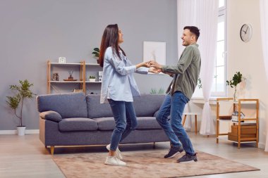 Mutlu, neşeyle gülen genç ev sahipleri evde dans edip yeni bir daireye taşınmayı kutluyorlar ya da birlikte mutlu bir ruh hali ve mutlu bir yaşam anının tadını çıkarıyorlar..