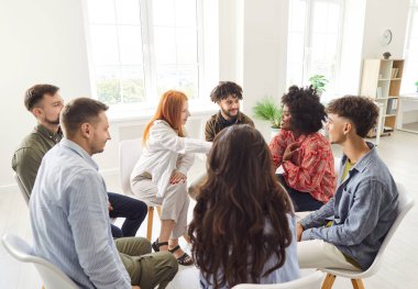 Gündelik giysiler içinde genç iş adamları iş projesini tartışıyor. Sandalyelerde daireler çiziyor ve ofiste görüşüyorlar. Şirket çalışanları yeni girişimler hakkında konuşuyor. Takım çalışması konsepti.