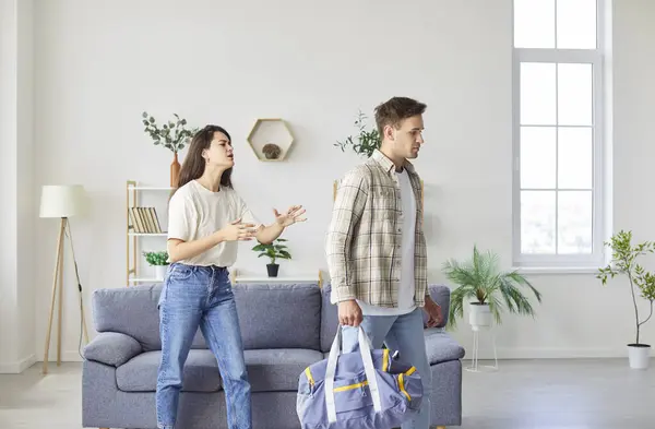 stock image A young couple is quarreling, the husband leaves his wife, close-up. A young woman asks a guy not to leave home. Concept domestic dispute, relationship problems, family decay, divorce