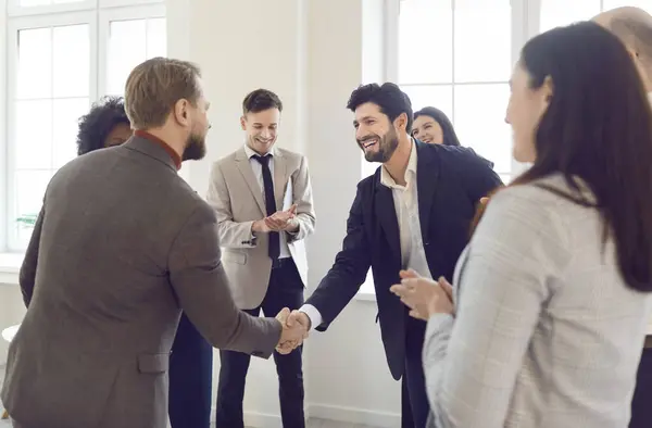 stock image Office business group, hr managers welcoming new employee to team, giving handshake candidate at job interview, meeting, diverse team thanking professional, leader shaking hand satisfied negotiations