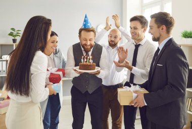 Ofis partisi, işçi doğum gününü mumlu pastayla kutlamak, mutlu iş arkadaşları. Bir grup işçi özel bir etkinlik için toplanıyor. Doğum günü ya da yıldönümü. Arkadaş canlısı şirket geleneği.