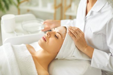 Güzellik uzmanlarının elleri kaplıca salonundaki kırışıklıkları önlemek için yaşlanma karşıtı yüz kremi sürüyor. Cilt bakımı, yüz bakımı ve güzellik tedavi konsepti için kozmetik prosedürler.