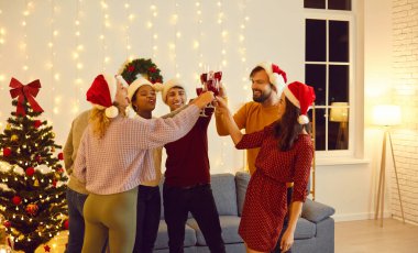 Mutlu yıllar ve mutlu Noeller. Arkadaşlar birlikte kış tatilini evde kutlar ve iyi şanslar ve neşe dileyerek kadeh tokuştururlar. Noel Baba şapkalı çok ırklı insanlar Noel 'le aynı odada.