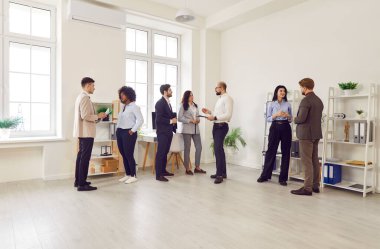 Ofisteki çeşitli çok ırklı iş arkadaşları takım toplantısında fikirleri tartışmak için gruplar halinde konuşuyorlar. Takım çalışması, çoklu etnik gruplarla ilgilenen iş adamları, iş yerinde beyin fırtınası işbirliğine gidiyor