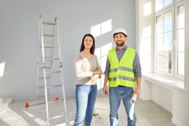Foreman ve bayan daire sahibi gelecekteki daire tasarımını tartışıyor. Tadilat süreci, iç dekorasyon, ev dekorasyonu hakkında konuşmak için evdeki sert şapka toplantısında profesyonel tamirci.
