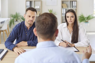 Aile bireyleri iş yerindeki bir toplantıda emlakçı ya da finans danışmanıyla iletişime geçerler. Görüşmede sigorta, mali planlama ve gayrimenkul işlemleri ele alınıyor.