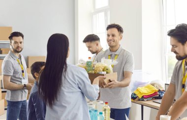 Gönüllü insanlar mutlu ekip, yiyecek bankası aileye yardım ediyor, hayır kurumunda gönüllü çalışan erkek gönüllüler bağış yapıyor, temel ihtiyaçları karşılayan hayır işleri yapıyor, ücretsiz bakım yapıyor.