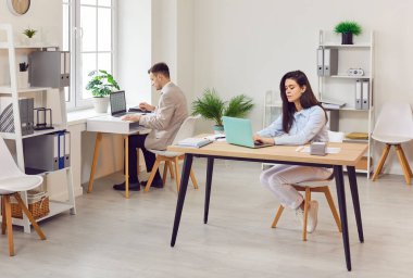 İş arkadaşları iş yerinde iş birliği yapar, iş günü boyunca birlikte çalışırlar. Laptoplar açık ve takım çalışması ruhuyla çevrimiçi işbirliği ve verimli iş uygulamalarına giriyorlar..