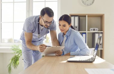 Doktor ve hasta birlikte panoya bakarlar. Doktor kadınlarla çalışır ve iletişim kurar ve anket, hizmet sözleşmesi, teşhis testi veya tıbbi laboratuvar analizi sonuçları gösterir.