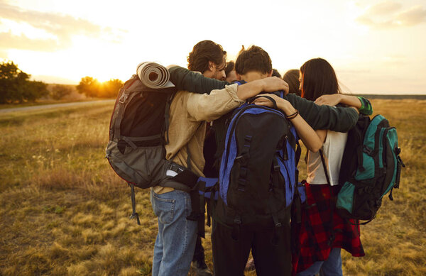 Команда друзей запечатлевает душераздирающий момент во время путешествия на природе во время отпуска. Они образуют тесный круг, обнимая друг друга с любовью, товариществом и радостью общих приключений.