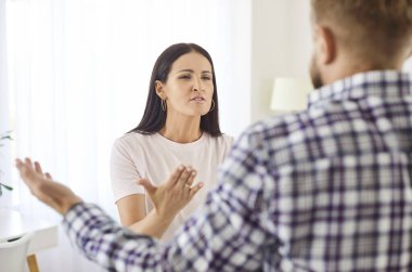 Evdeki oturma odasında kavga eden, birbirine bağıran genç bir çift. Mutsuz adam ve kadın ilişkilerde sorun yaşıyor. Evlilik kavgası ve boşanma kavramı.