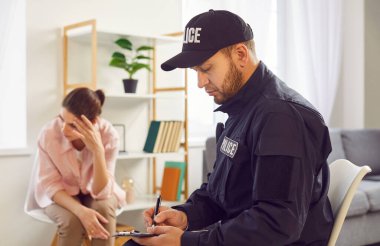 Polis ya da dedektif bir soygun kurbanı kadını sorgulamak ya da bir soruşturma yürütüyor. Polisin suçların soruşturulmasında ve hukukun korunmasında oynadığı rolü vurgulayan kanun uygulayıcıları.