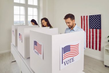 Amerikan vatandaşları oy merkezindeki oy kullanma merkezinde sıra sıra bekleyen ABD 'li seçmenler biz bayraklar oy pusulalarını oy kabinine koyacaklar. Demokrasi ve seçim günü konsepti.