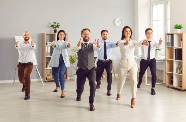 Yogi bürosu çalışanları yoga pozisyonunda, resmi çalışan grup egzersiz yaparken zihin dinlendirici beden takınıyor. Aktif işçiler dinlenme, sağlık, yaşam dengesi için birlikte meditasyon, iş başarısı