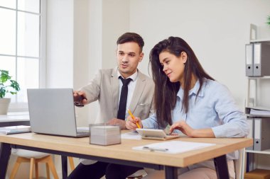 Masadaki ciddi iş adamları ofis giderleri yönetimi ile meşgul, hesaplamak için hesap makinesi kullanın, güvenli e-bankacılık uygulaması, finans ve muhasebe yardımı ile faturaları ödemeyi öğrenin