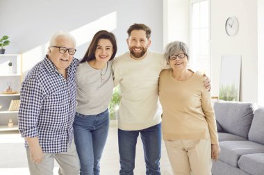 Mutlu aile portresi, gülümseyen yaşlı ebeveynler ve yetişkin çocuklar, yaşlı ve genç birlikte evde. Yaşlı anne, baba, büyükanne, büyükbaba sevgi dolu sevgi dolu güven, aile barışı, nesil