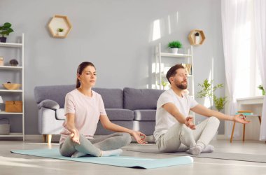 Yoga seansı sırasında konsantre aile çifti lotus pozunda meditasyon yapar. Bu aile aktivitesi Zen ve refah duygusunu arttırıyor, yoga eğitimini ve egzersiz rutinini geliştiriyor..