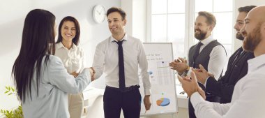 Mutlu gülümseyen şirket çalışanları modern ofiste el sıkışıyorlar. İş adamları, bir toplantıda meslektaşlarıyla başarılı bir ortaklığa sevinerek alkışladılar. Pankart.