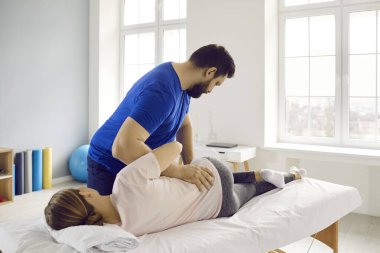 Profesyonel fizyoterapist, kayropraktik uzmanı, osteopat ya da genç bir kadına yardım eden, sırt ağrısını tedavi eden, kaslarını gevşeten manuel terapist. Fizik tedavi, rehabilitasyon, ağrı kesici kavramı