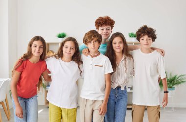 Memleketteki çocukların ve çocukların mutlu bir grup portresi. Gençler de dahil olmak üzere çeşitli öğrenciler birlik ve dostluğu temsil eden mutlu bir şekilde toplandılar..