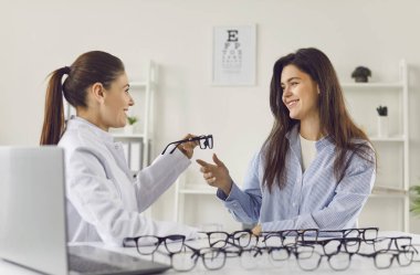 Oftalmolog, doğru gözlüğü bulmaya yardım ediyor. Optik çerçevesi mükemmel. Müşteri ve hasta için. Doğru çifti almak için tıbbi klinikte gözlük seçmek, mağazadan seçmek.