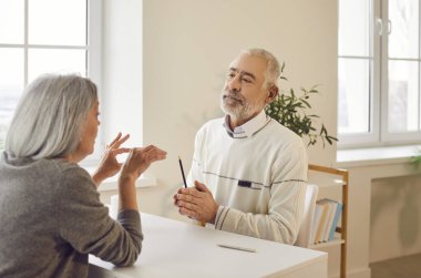 Gary saçlı yaşlı çift oturma odasında oturmuş konuşuyor ve içeride bir şeyler tartışıyorlar. Kıdemli erkek ve kadın evde iletişim kuruyor. Emeklilik kavramında aile ilişkisi