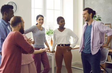 Neşeli genç ve çokuluslu arkadaşlar komik hikayeler anlatarak iletişim kurarlar. Beyaz ve Afrikalı Amerikalı kadınlar ve erkekler evde durup gülümseyerek arkadaşlarını dinliyorlar..