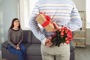 Sevgililer Günü. Çiçek tutan bir adamın arka görüntüsü ve bir kıza elinde bir hediye verir..