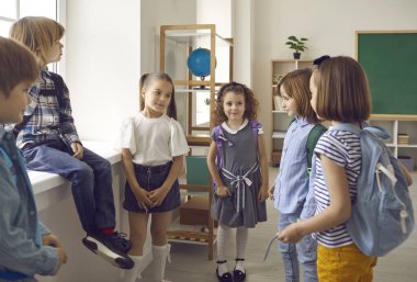 Utangaç ilkokul çocukları birbirleriyle ilk kez tanışıyorlar. Okul çantalı bir grup çocuk sınıfta dikilip konuşuyor. Sevimli küçük kızlar ve oğlanlar tanışır ve okulda yeni arkadaşlar edinirler.
