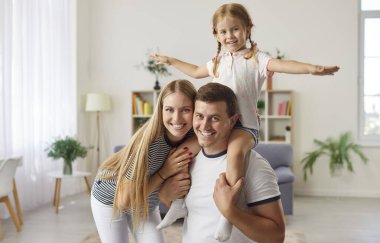 Evde kızıyla mutlu bir ebeveynin portresi. Aile sevgi ve şefkat gösterir, sıcak ve sevgi dolu bir ortamda bağ kurar, kaliteli zaman geçirdikçe ilişkileri güçlendirir..