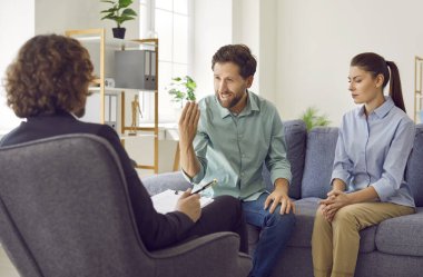 Genç evli çift koltukta oturup psikologla konuşuyor ve danışmanlık bürosunda sorun ve çözüm bulmaya çalışıyorlar. Aile terapisi, ilişki ve akıl sağlığı konsepti.