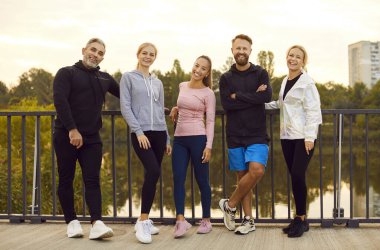 Şehir köprüsündeki bir grup genç atletik insanın portresi. Eğitimden sonra gülümseyen arkadaşlar. Spor yaşam tarzı konsepti. Meslektaşları şehir maratonu için hazırlamak, meydan okuma