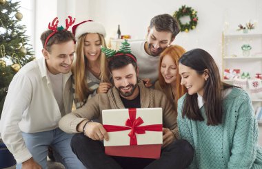 Bir grup arkadaş evde yılbaşı ya da yeni yıl partisinde hediye paketi açıyorlar. Bayram kutlaması şenlikli bir parti atmosferinde neşe, heyecan ve beraberlik getirir..