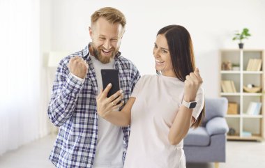 Evli çiftler büyük indirim alırken eğleniyorlar, nakit para kazanıyorlar, maaş alıyorlar, internette büyük paralar kazanıyorlar. İki insan mutlu yüzlü akıllı telefona bakar ve neşeyle bağırır.