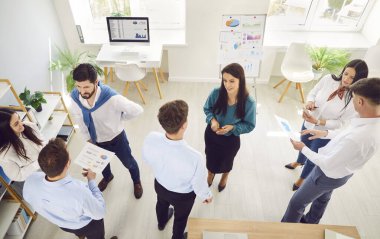 Bir grup kendine güvenen iş adamı erkek ve kadın bir toplantı sırasında ofiste konuşuyor. Şirket çalışanları içeride çalışıyor, iş ve iş projelerini tartışıyor. Takım çalışması konsepti.