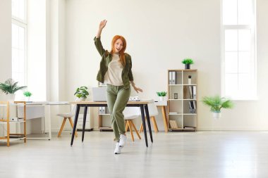 Coşkulu, genç, güzel, kızıl saçlı kız, oturma odasında dans eden kız öğrenci, güzel ev hanımı, yeni bağımsız bir milenyum sahibi, kendinden emin, genç ve güzel, kendi evine yalnız taşınıyor.