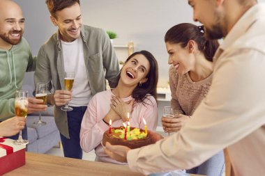 Mutlu arkadaşlar grubu, doğum gününde masada oturan ve elinde şampanya kadehleri olan genç bir kızı tebrik ediyor. Mutlu yıllar ve kutlama konsepti.